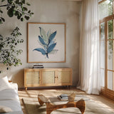 Luxe Leaf II by Chris Paschke. Shown in a natural wood frame in a cozy modern living room. Available as an archival giclee rolled canvas, fine art paper, or poster print. SKU 84573a.