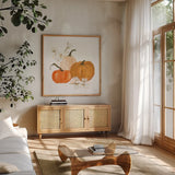 Pumpkins and Cotton II by Chris Paschke. Shown in a natural wood frame in a cozy modern living room. Available as an archival giclee rolled canvas, fine art paper, or poster print. SKU 81867a.