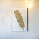 Pure Gold Feather V by Chris Paschke. shown as a paper print in a natural frame. Available as a archival giclee rolled canvas, fine art paper, or poster print. SKU 28003h.