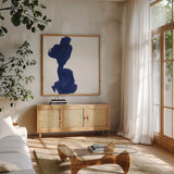 Swash I Indigo by Chris Paschke. Shown in a natural wood frame in a cozy modern living room. Available as an archival giclee rolled canvas, fine art paper, or poster print. SKU 68772a.