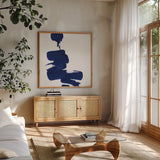 Swash IV Indigo by Chris Paschke. Shown in a natural wood frame in a cozy modern living room. Available as an archival giclee rolled canvas, fine art paper, or poster print. SKU 68775a.