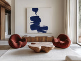Swash IV Indigo by Chris Paschke. Shown as extra-large giant wall art in a modern living room. Available as an archival giclee rolled canvas, fine art paper, or poster print. SKU 68775a.