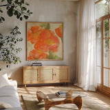Tangerine Poppies I by Chris Paschke. Shown in a natural wood frame in a cozy modern living room. Available as an archival giclee rolled canvas, fine art paper, or poster print. SKU 50257a.