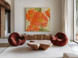 Tangerine Poppies I by Chris Paschke. Shown as extra-large giant wall art in a modern living room. Available as an archival giclee rolled canvas, fine art paper, or poster print. SKU 50257a.