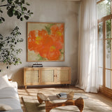 Tangerine Poppies II by Chris Paschke. Shown in a natural wood frame in a cozy modern living room. Available as an archival giclee rolled canvas, fine art paper, or poster print. SKU 50258a.