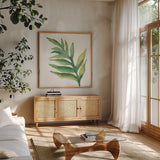 Tropical Palm I by Chris Paschke. Shown in a natural wood frame in a cozy modern living room. Available as an archival giclee rolled canvas, fine art paper, or poster print. SKU 22673a.