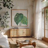 Tropical Palm II by Chris Paschke. Shown in a natural wood frame in a cozy modern living room. Available as an archival giclee rolled canvas, fine art paper, or poster print. SKU 22674a.