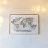 World Map Blush v2 by Chris Paschke. shown as a paper print in a natural frame. Available as a archival giclee rolled canvas, fine art paper, or poster print. SKU 53933i.