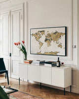 World Map Gold Leaf by Chris Paschke. shown as a framed stretched canvas in a living room above a console. Available as a archival giclee rolled canvas, fine art paper, or poster print. SKU 53225i.