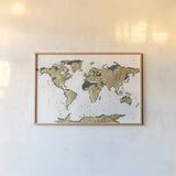 World Map Gold Leaf by Chris Paschke. shown as a paper print in a natural frame. Available as a archival giclee rolled canvas, fine art paper, or poster print. SKU 53225i.