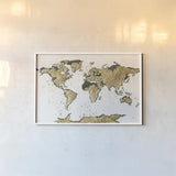 World Map Gold Leaf by Chris Paschke. shown as a paper print in a white frame. Available as a archival giclee rolled canvas, fine art paper, or poster print. SKU 53225i.