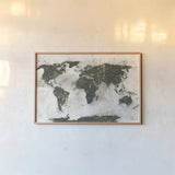World Map Gold Speckle by Chris Paschke. shown as a paper print in a natural frame. Available as a archival giclee rolled canvas, fine art paper, or poster print. SKU 53226i.