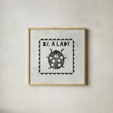 Ladybug Stamp Be A Lady by Courtney Prahl. Shown in a natural wood glass frame for a timeless modern aesthetic. Available as an archival giclee rolled canvas, fine art paper, or poster print. SKU 52084a.