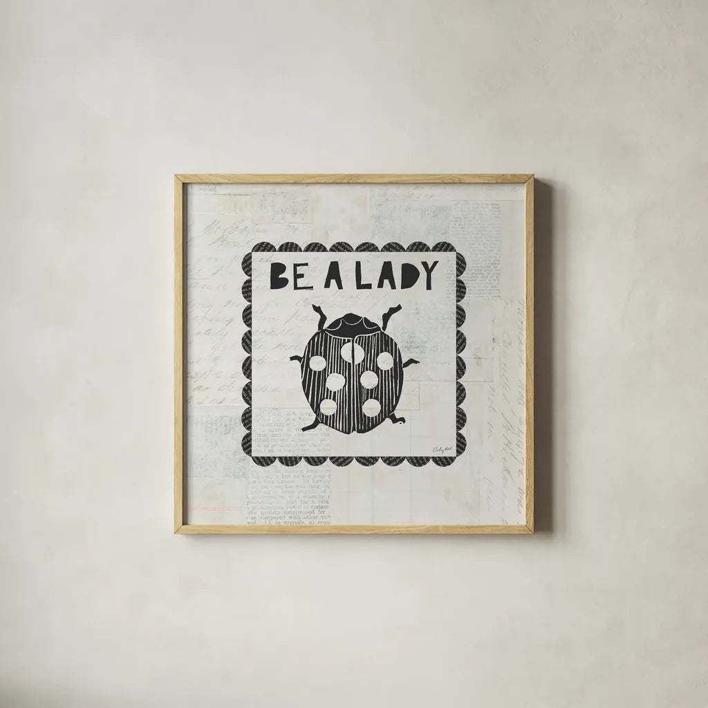 Ladybug Stamp Be A Lady by Courtney Prahl. Shown in a natural wood glass frame for a timeless modern aesthetic. Available as an archival giclee rolled canvas, fine art paper, or poster print. SKU 52084a.
