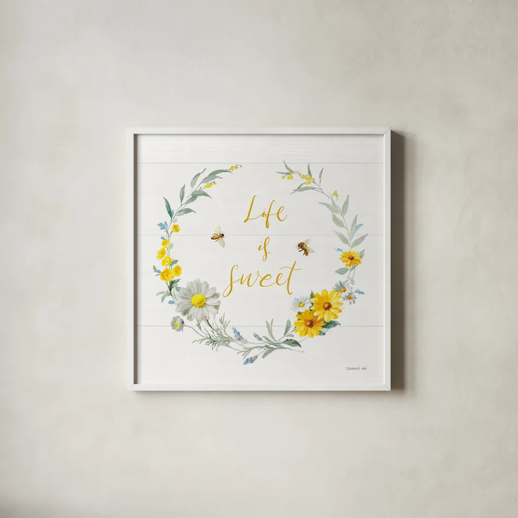 Bees and Blooms_Life is Sweet Wreath by Danhui Nai. Shown in a crisp white glass frame for a clean and minimalist style. Available as an archival giclee rolled canvas, fine art paper, or poster print. SKU 78405a.