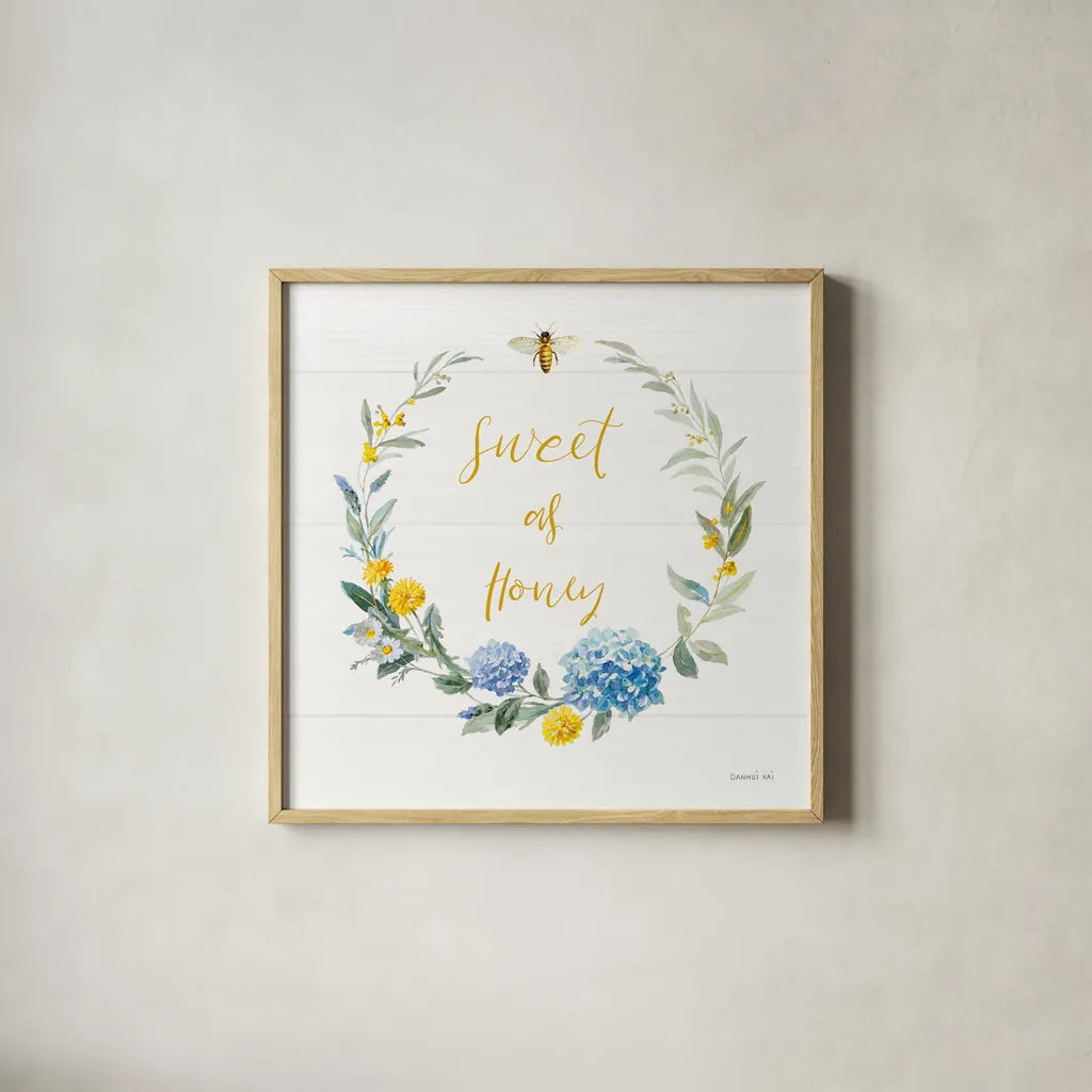 Bees and Blooms_Sweet As Honey Wreath by Danhui Nai. Shown in a natural wood glass frame for a timeless modern aesthetic. Available as an archival giclee rolled canvas, fine art paper, or poster print. SKU 78406a.