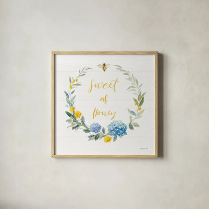 Bees and Blooms_Sweet As Honey Wreath by Danhui Nai. Shown in a natural wood glass frame for a timeless modern aesthetic. Available as an archival giclee rolled canvas, fine art paper, or poster print. SKU 78406a.