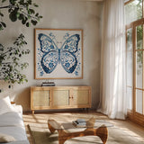 Blue Butterfly II by Danhui Nai. Shown in a natural wood frame in a cozy modern living room. Available as an archival giclee rolled canvas, fine art paper, or poster print. SKU 99153a.