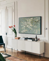 Dogwood in Spring on Blue by Danhui Nai. shown as a framed stretched canvas in a living room above a console. Available as a archival giclee rolled canvas, fine art paper, or poster print. SKU 28719i.