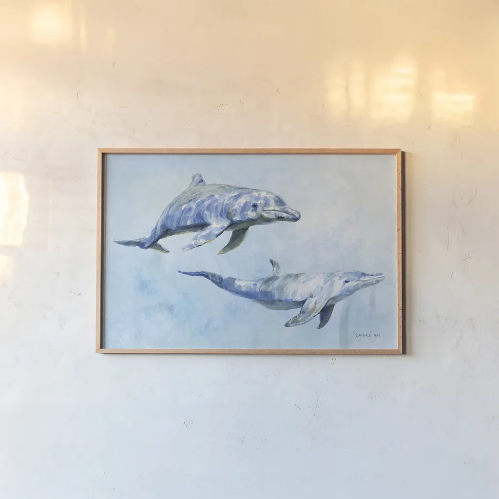 Graceful Dolphins I by Danhui Nai. shown as a paper print in a natural frame. Available as a archival giclee rolled canvas, fine art paper, or poster print. SKU 93408i.