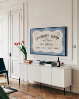 Laundry Day VII Bright Blue by Danhui Nai. shown as a framed stretched canvas in a living room above a console. Available as a archival giclee rolled canvas, fine art paper, or poster print. SKU 75987i.