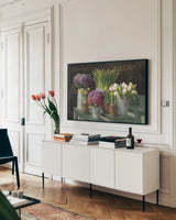 Les Fleurs Printemps on Black by Danhui Nai. shown as a framed stretched canvas in a living room above a console. Available as a archival giclee rolled canvas, fine art paper, or poster print. SKU 24674i.