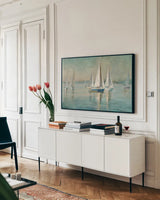 Sailboats at Sunrise Crop by Danhui Nai. shown as a framed stretched canvas in a living room above a console. Available as a archival giclee rolled canvas, fine art paper, or poster print. SKU 18931i.