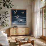 Seagulls Over the Blue Sea by Danhui Nai. Shown in a natural wood frame in a cozy modern living room. Available as an archival giclee rolled canvas, fine art paper, or poster print. SKU 102555a.