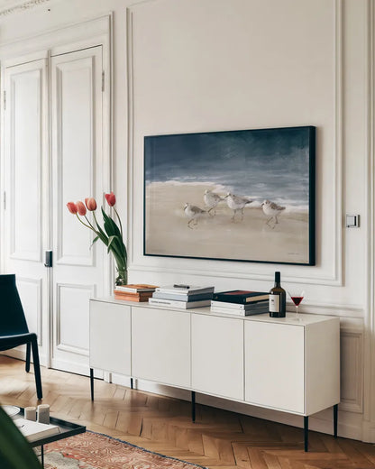 Shorebirds on Sand I Blue by Danhui Nai. shown as a framed stretched canvas in a living room above a console. Available as a archival giclee rolled canvas, fine art paper, or poster print. SKU 88377i.