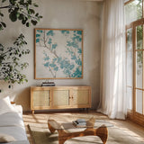 Teal Cherry Blossoms II on Cream Aged no Bird by Danhui Nai. Shown in a natural wood frame in a cozy modern living room. Available as an archival giclee rolled canvas, fine art paper, or poster print. SKU 31635a.