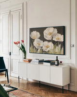 White Anemones on Black by Danhui Nai. shown as a framed stretched canvas in a living room above a console. Available as a archival giclee rolled canvas, fine art paper, or poster print. SKU 68764i.