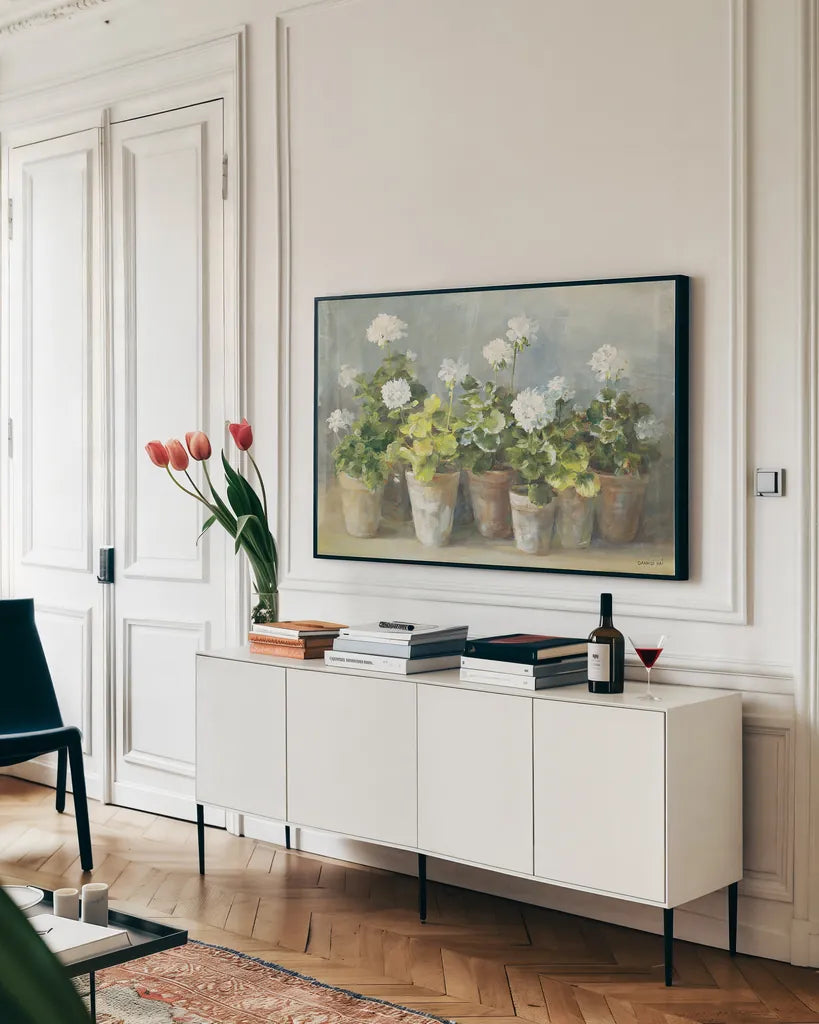 White Geraniums by Danhui Nai. shown as a framed stretched canvas in a living room above a console. Available as a archival giclee rolled canvas, fine art paper, or poster print. SKU 13244i.