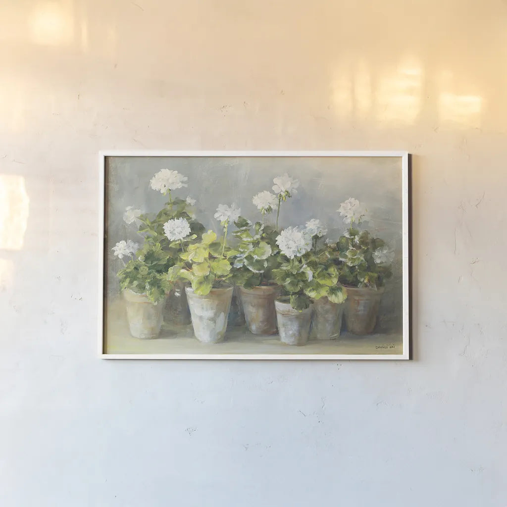 White Geraniums by Danhui Nai. shown as a paper print in a white frame. Available as a archival giclee rolled canvas, fine art paper, or poster print. SKU 13244i.
