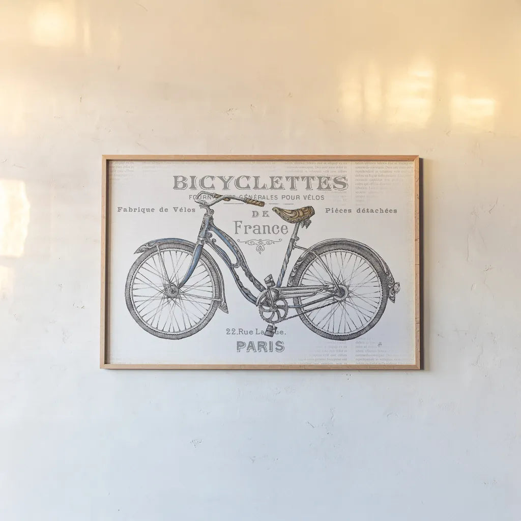 Bicycles II by Daphne Brissonnet. shown as a paper print in a natural frame. Available as a archival giclee rolled canvas, fine art paper, or poster print. SKU 28774i.