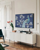 Peacock Allegory II Blue by Daphne Brissonnet. shown as a framed stretched canvas in a living room above a console. Available as a archival giclee rolled canvas, fine art paper, or poster print. SKU 37505i.