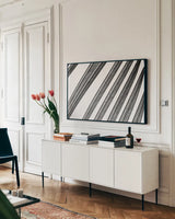 BW Fern II by Deborah Revell. shown as a framed stretched canvas in a living room above a console. Available as a archival giclee rolled canvas, fine art paper, or poster print. SKU 92033i.