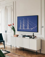 Blue Schooner I by Deborah Revell. shown as a framed stretched canvas in a living room above a console. Available as a archival giclee rolled canvas, fine art paper, or poster print. SKU 104263i.