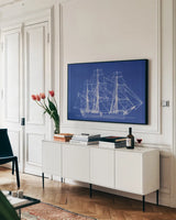 Blue Schooner II by Deborah Revell. shown as a framed stretched canvas in a living room above a console. Available as a archival giclee rolled canvas, fine art paper, or poster print. SKU 104264i.
