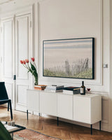 Coastal Fence I by Deborah Revell. shown as a framed stretched canvas in a living room above a console. Available as a archival giclee rolled canvas, fine art paper, or poster print. SKU 102392i.