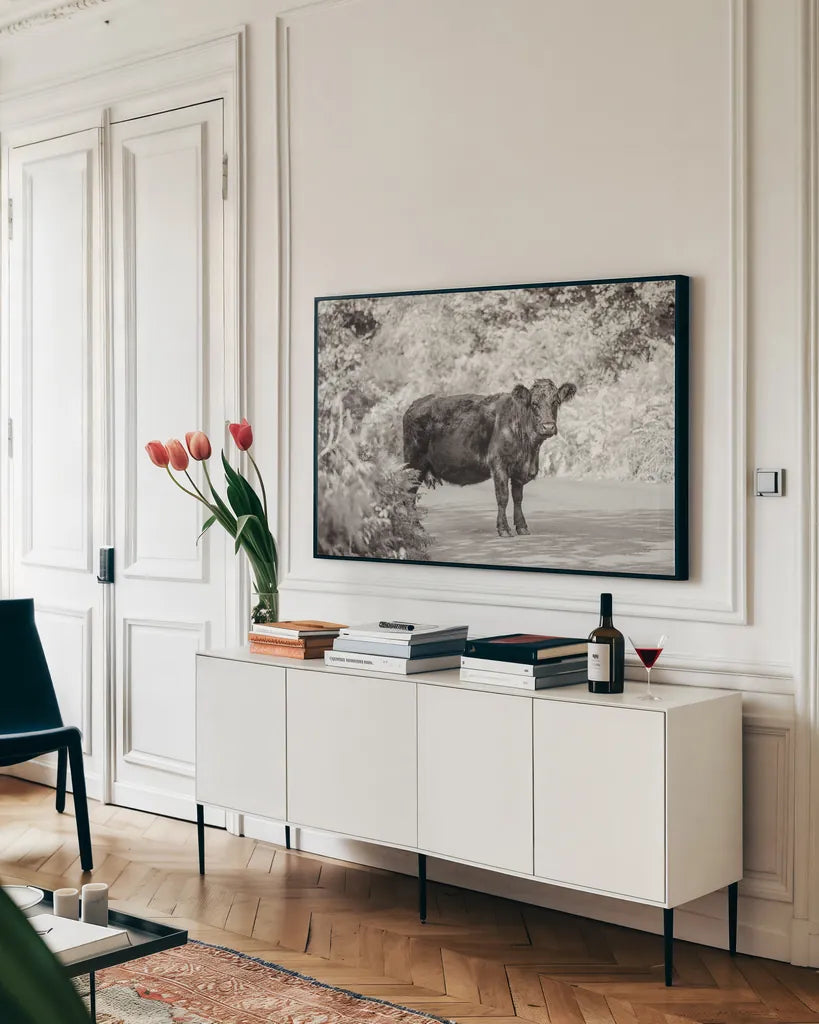 Cow on the Road I by Deborah Revell. shown as a framed stretched canvas in a living room above a console. Available as a archival giclee rolled canvas, fine art paper, or poster print. SKU 94282i.