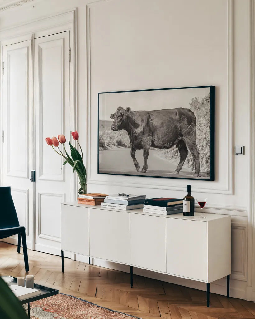 Cow on the Road II by Deborah Revell. shown as a framed stretched canvas in a living room above a console. Available as a archival giclee rolled canvas, fine art paper, or poster print. SKU 94283i.