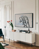 Fiddle Fern I by Deborah Revell. shown as a framed stretched canvas in a living room above a console. Available as a archival giclee rolled canvas, fine art paper, or poster print. SKU 94826i.