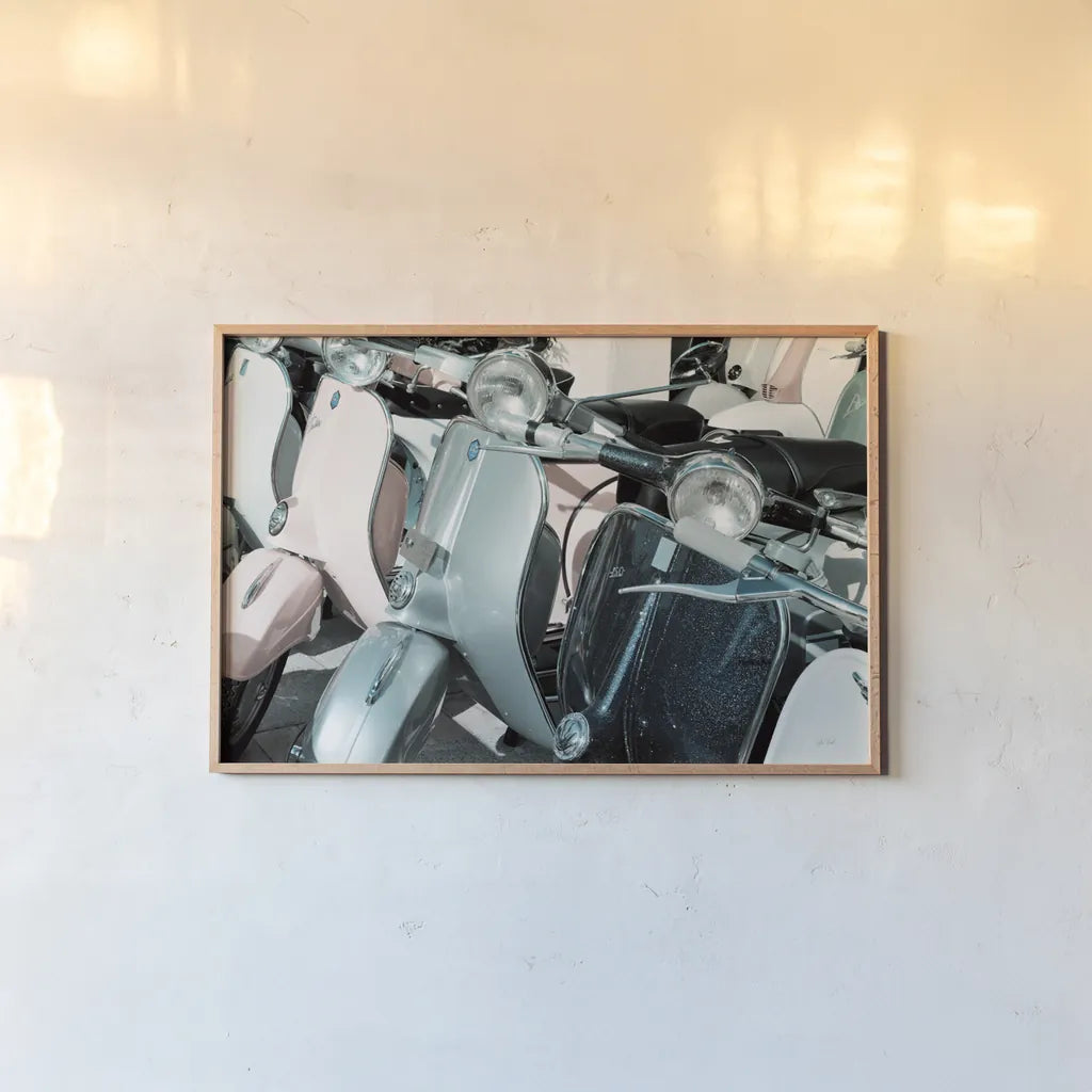 Italian Scooter III by Deborah Revell. shown as a paper print in a natural frame. Available as a archival giclee rolled canvas, fine art paper, or poster print. SKU 91134i.