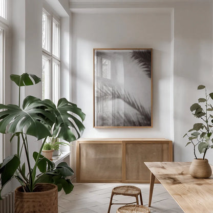 Palm Shadow Afternoon I by Deborah Revell. shown as a print in a natural wood frame in a dining room. Available as a archival giclee rolled canvas, fine art paper, or poster print. SKU 94352h.