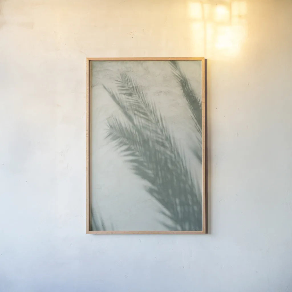 Palm Shadow I by Deborah Revell. shown as a paper print in a natural frame. Available as a archival giclee rolled canvas, fine art paper, or poster print. SKU 94354h.
