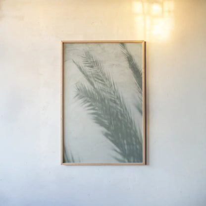 Palm Shadow I by Deborah Revell. shown as a paper print in a natural frame. Available as a archival giclee rolled canvas, fine art paper, or poster print. SKU 94354h.