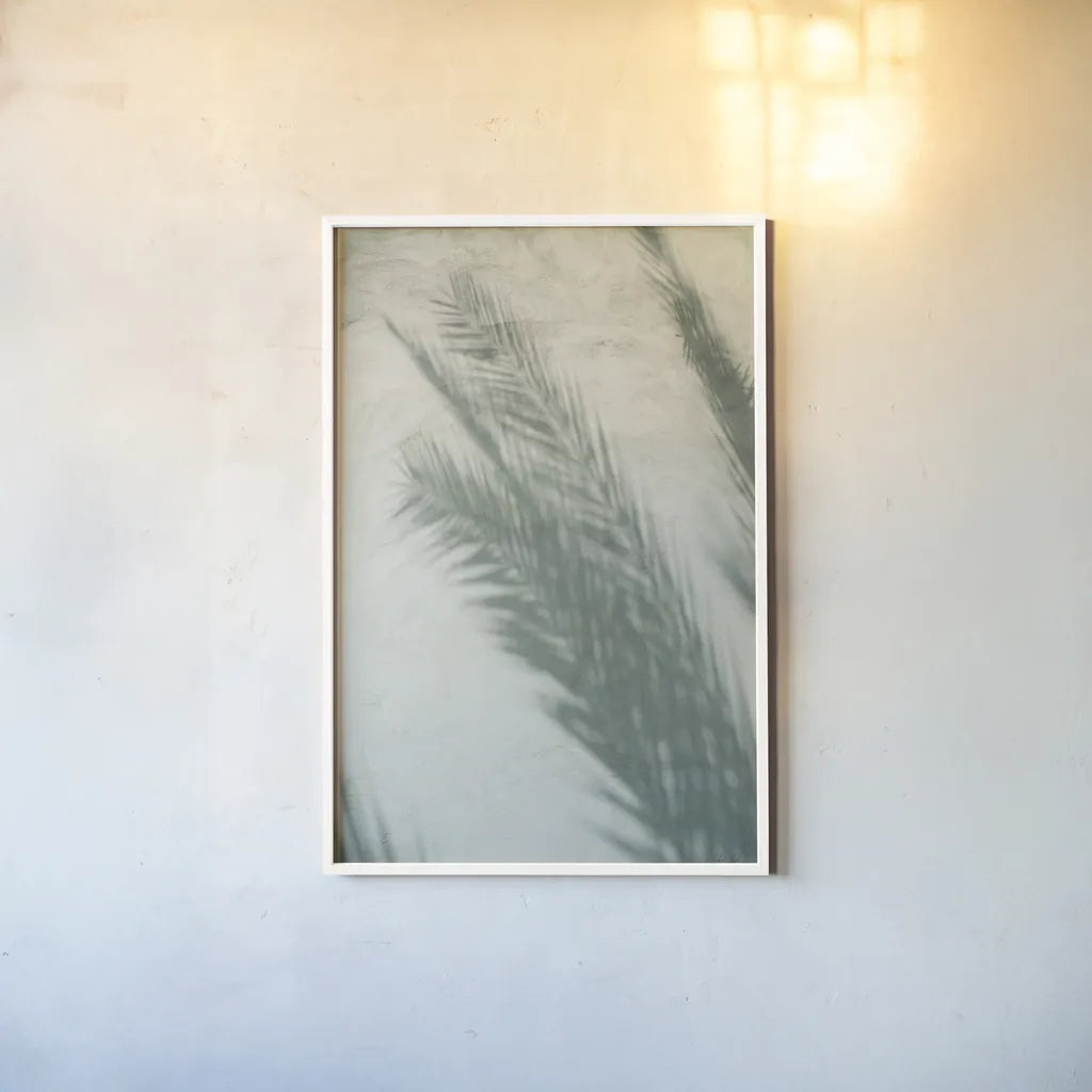 Palm Shadow I by Deborah Revell. shown as a paper print in a white frame. Available as a archival giclee rolled canvas, fine art paper, or poster print. SKU 94354h.