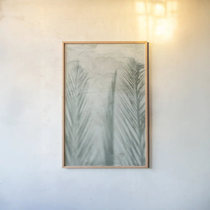 Palm Shadow II by Deborah Revell. shown as a paper print in a natural frame. Available as a archival giclee rolled canvas, fine art paper, or poster print. SKU 94355h.