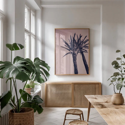Pink Palms I by Deborah Revell. shown as a print in a natural wood frame in a dining room. Available as a archival giclee rolled canvas, fine art paper, or poster print. SKU 94375h.