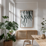 Simple Eucalyptus II by Deborah Revell. shown as a print in a natural wood frame in a dining room. Available as a archival giclee rolled canvas, fine art paper, or poster print. SKU 102715h.